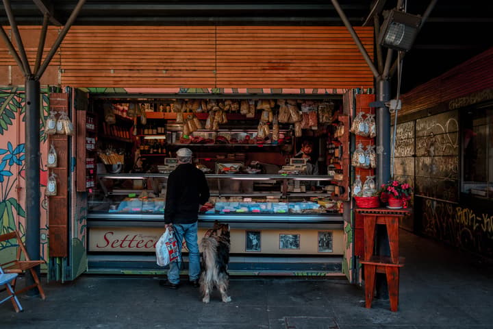 Italian and his dog doing the groceries in one of the open markets of Rome, 2019
